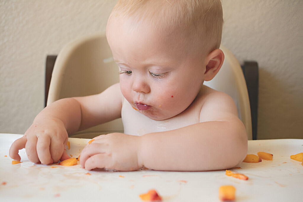 Bebé comiendo trozos de comida Bebé comiendo trozos de comida